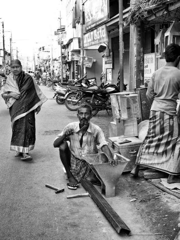 A metalworker at work by his street side workshop, Madurai, Tamil Nadu, India